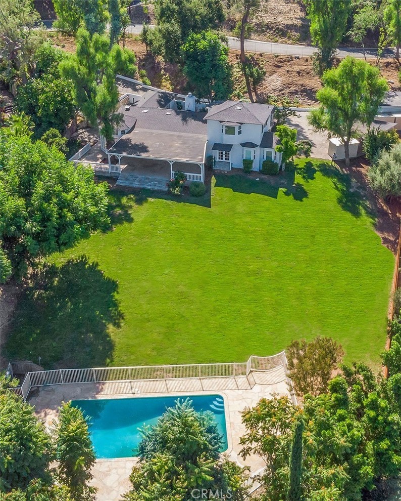 Tucked behind a private gate on a lush 1 ACRE lot, this stunning 4-bed, 3.5-bath home offers ultimate privacy and indoor-outdoor living. An open floor plan features French doors throughout, a cozy fireplace, and a gourmet kitchen with granite countertops. Enjoy the beautiful front courtyard, spacious 600 sq ft covered patio, and sweeping views of the entire property—including a large gated pool. The detached garage includes a finished 200 sq ft bonus space ideal for a gym, office, playroom, or studio. Move-in ready today!