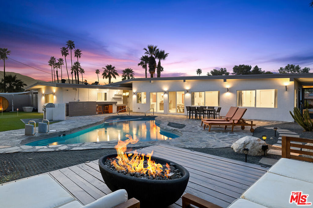 Unique opportunity in South Palm Desert to own a fully renovated Mid Century modern home with clean architectural lines, curb appeal, and tastefully restored with integrity to its original design while upgraded for modern living. This home sits on an expansive 10,890 sqft lot with great mountain views featuring 4BD 3.5BA in the main house plus a fully permitted ADU (462 sq ft approximately) with a full bathroom + kitchen that could be used as a Guest House, Pool House, or Income unit. The bright and open floor plan is equipped with a stunning kitchen that features SMEG Appliances, quartz countertops, an oversized custom skylight, top of the line custom cabinets with floating shelves and LED lighting, brass VIGO faucet, polished marble mosaic backsplash, and brass gold pendants sitting over a spacious waterfall edge island. A slatted wood panel wall on one side and a breakfast nook on the other complete this open concept. A formal dining area sits off a sliding door which leads to an entertainer's backyard that features a spacious tiled pool/spa, a floating sundeck, outdoor dining area, bar area, propane firepit, LION 4 burner grill, putting green with a turf area, desert landscaping surrounded by tall green hedges, DG, palo verdes, cactuses, lemon tree, agaves, golden barrels, and low voltage landscaping lighting. The floors in the living area are matte porcelain tile which continue on to the spacious bedrooms and junior primary suite with an en suite bathroom. The oversized primary bedroom has a nice separation from the other bedrooms on the opposite wing of the house. The primary has its own enclosed patio with a decorative vintage fireplace and beautiful tile as well as an oversized bathroom with a shower and a freestanding soaking bathtub, dual vanities, and a skylight. Other features include a powder room with festive tile and wall paper, pocket door, leased solar panels, custom doors, VIGO bathroom faucets, floating vanities, recessed lighting, light dimmers, brass modern door handles, new HVAC system with two additional mini split units, NEST thermostat, new water heater, new windows, electrical upgrades, plumbing upgrades, and many structural upgrades. A wellness area with a barrel sauna and cold plunge are well appointed in the backyard. Large parking driveway with a carport and Tesla EV charger! Close proximity from the best restaurants and shopping at El Paseo. Great golf courses like Vintage, El Dorado, Shadow Mountain, and Indian Wells are all a golf cart away. Listing Agent is the owner. No HOA's!