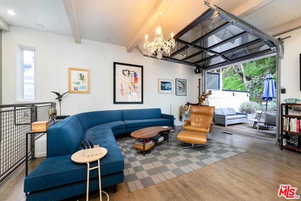 This New York City loft style home with modern organic touches in Lower Laurel Canyon is the perfect blend of industrial cool and cozy comfort, designed for entertaining, creating, or just kicking back and enjoying life, amidst this naturally elegant setting. This open concept main living space feels like a voluminous great space, with high ceilings, exposed beam coffered ceilings, and a garage style roll up window that brings in tons of natural light and fresh air, creating a seamless indoor outdoor flow. The large wood deck connects the industrial innards with the lush green hillside exterior and all the nature the Canyon has to offer, from native plants and succulents to hummingbirds and hawks. Whether you're hosting friends or enjoying a quiet morning, this space provides a private and comfortable space to experience life's simple pleasures. The celebrity chef designed kitchen is sleek and efficient, stretching almost the entire length of the main floor, with high end stainless steel appliances like the Subzero refrigerator and Wolf stove, custom cabinetry with beaucoup cupboard space all around the top, and plenty of prep space on the supple soapstone countertops. It's ready for everything from casual breakfasts to gourmet dinners. The primary bedroom is tucked away for privacy, featuring ample wall closet space, with an ensuite bathroom with double sinks, a walk-in rain shower with organic flair, and a walk-in closet for additional wardrobe space. Downstairs, the second bedroom features an ensuite bathroom with bathtub and a private entrance. This flex space is perfect as a guest suite, creative studio, home gym, entertainment room, or office workspace--the possibilities are endless! Plus, this room opens out to its own covered patio, an extra outdoor space ideal for a host of recreational activities, or just taking a nap in the shade. To boot, the large garage provides space for 2 cars parked side by side with an easy level entry off the street, in addition to a stacked washer and dryer and lots of extra storage space. Just minutes from Laurel Canyon Country Store and the Sunset Strip, in the highly rated Wonderland Avenue Elementary School district, this home is functional as it is fun and practical. Available furnished or unfurnished, it's also incredibly convenient and totally turnkey. Come see it in person--you won't want to leave!