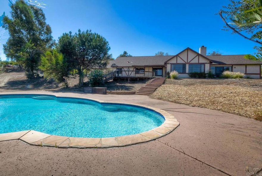 Don't miss this amazing opportunity to own a private, gated, fully fenced 4BR/3.5BA single level home on over 1.25 acres, big enough for RV parking and an ADU! Enjoy gorgeous views from the house & back deck. On the lower level of the property you'll find an in ground swimming pool with slide. The inviting entry welcomes you into an oversized family room with stone fireplace, wet bar and vaulted ceiling. A cook's eat-in kitchen offers lots of cabinets and countertops, built-in desk, trash compactor and more. Entertain guests in style with the formal living room and dining room with coffered ceiling. The powder room is big enough to convert into a full bath. The primary suite boasts a bath with dual sinks and closets and a slider out to the private back yard. Other features include new furnace and a/c, spacious bathrooms, laundry room and an outdoor shed on the property. Long term owner, no HOA and a great location that's city close with a country feel. Close to schools, shopping, freeways, San Pasqual Valley, San Diego Zoo and Safari Park, North County Mall and more. ** Shown by appt only**