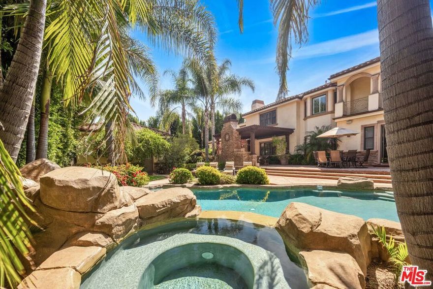 Discover unparalleled luxury in this stunning, privately-gated Mediterranean masterpiece, nestled in the prestigious Sutton Estates neighborhood of the Sherman Oaks flats. Set back 70 feet from the street, this exceptional compound offers 9,050 square feet of refined living space, blending grand elegance with effortless comfort. Entertain with ease in the expansive chef's kitchen, featuring dual dishwashers and seamless flow into the family room and resort-style backyard. Indulge in cinematic experiences within the gorgeous, dedicated theater/screening room, complete with a wet bar. The main residence boasts 5 luxurious bedrooms and an executive office, ensuring ample space for family and work. A detached guest house provides a private retreat, featuring a full bedroom, living area, kitchen, and walk-in closet. Beyond, is a "Casita" studio offering a versatile space for a gym, office, maids quarters or creative studio, complete with a 3/4 bath, laundry, and walk-in closet. The sprawling, over half-acre grounds are a haven of tranquility, showcasing meticulously landscaped gardens and mature trees. The resort-style backyard is an entertainer's dream, featuring an outdoor kitchen, BBQ, dual gas and wood-burning fireplace with a beamed trellis ceiling.  A motor court accommodates 10+ vehicles, alongside a 4-car garage. This landmark property presents a rare opportunity to own a slice of Sherman Oaks paradise. Ideal for extended families, car enthusiasts, or those seeking an extraordinary private retreat, this compound offers a lifestyle of unparalleled luxury and convenience. Schedule your private showing today and experience the grandeur firsthand.  MOVE-IN-READY CONVENIENCE; FURNITURE IS ALSO NEGOTIABLE.