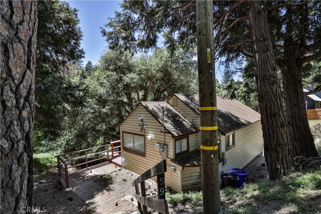 Nestled in the Valley of the Moon area of Crestline, this charming cabin offers the perfect mountain retreat. A flight of stairs leads you to a spacious deck—ideal for enjoying the fresh mountain air. Step into a cozy covered porch, perfect for shedding wet boots after a snowy day.
Inside, you'll find original wood floors and high ceilings that enhance the classic cabin ambiance. A stand-alone gas fireplace adds warmth and charm for those chilly winter nights. The updated kitchen features modern cabinets and countertops, blending style with functionality.
Downstairs, the first room greets you upon entry—ideal as a home office, nursery, or guest space. The second bedroom offers added privacy with its own door.
Conveniently located near Lake Gregory and the town, and just a 20-minute drive to Lake Arrowhead, this delightful cabin makes an ideal weekend getaway or vacation retreat.