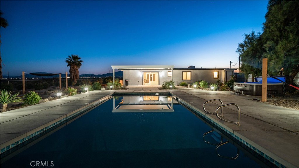 Welcome to An Oasis in the Desert. On this expansive 26.6-acre lot you will find privacy, peace and perfection. The main structure is a Mid-Century brick home with 3 Bedrooms and 2 Baths, all beautifully renovated by a local General Contractor. This Complete Renovation took the original structure down to the bare bricks. From this basis, a brand new home was constructed keeping the original, solid brick frame. A new interior was constructed adding all new electrical, plumbing, fixtures, and appliances. This double-walled and insulated structure provides the type of quiet we all desire as well as protection from the outside elements. When being outdoors is craved, this property boasts a brand-new inground pool, complete with a floating pathway around the pool, the spa, and between the house and guest house. This outdoor area is surrounded by a wide variety of original and new indigenous plants and rocks to create a stunning tropical environment. All plants are on a sprinkler system to make their enjoyment stress-free. The guest quarters is found at the far end of the pool area and has an outdoor shower and both an exterior access bathroom and an interior bath. The above-ground spa is also brand new and has the perfect adjustments for the jets and temperatures to help you unwind. The attached 20-acre parcel is perfect for exploring, hiking or developing into anything a new owner may desire. The water supply is a well that was recently upgraded. Enjoy bird watching or enjoying the night sky beyond what you have ever experienced. This property has a gorgeous Mountain Views to both the North and South, where the world-famous Joshua Tree National Park is located. The drive to the East Entrance of the park takes only 19 minutes.