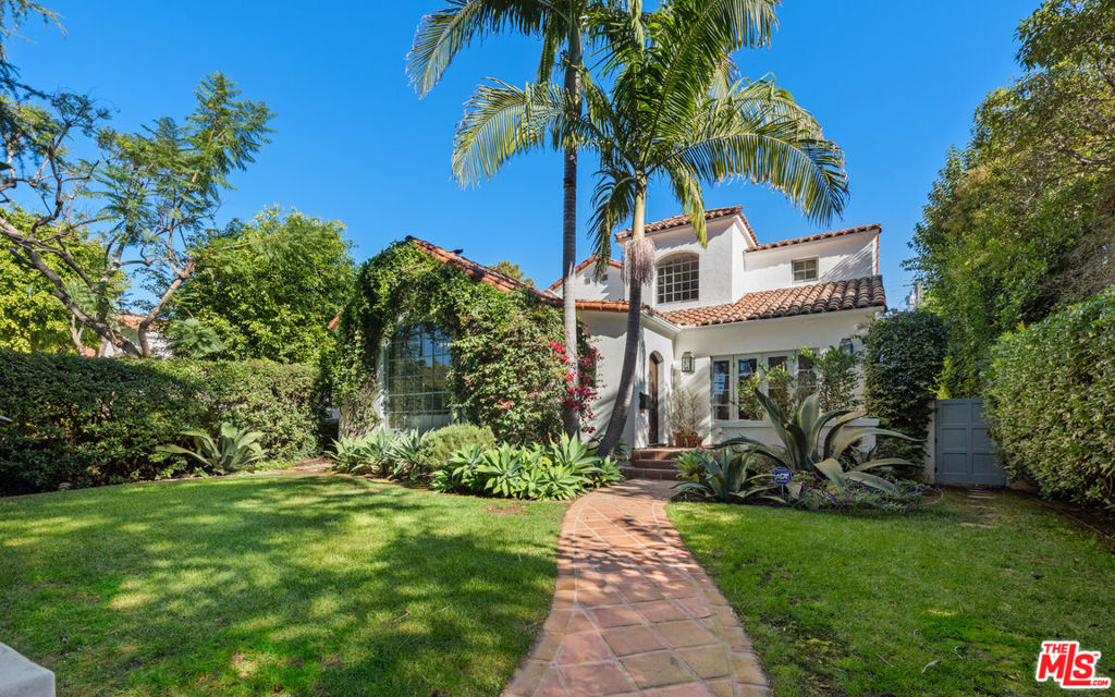 Ideally located North of Montana in Santa Monica is this stunning 1925 Spanish architectural gem that exudes classic elegance on the outside and comfortable modernity on the inside. Tastefully remodeled with 4 bedrooms and 5 bathrooms plus an office/den, the home features beautifully refinished hardwood floors, flowing seamlessly throughout. The living room, adorned with a giant arched window, is filled with natural light which highlights the soaring high ceilings and a large detailed fireplace. The gourmet kitchen includes high-end appliances, a generously sized island, and opens to a breakfast room where French doors lead to the backyard. For formal gatherings, the adjacent dining room provides an exquisite setting to spend evenings with friends and family. The primary suite is a relaxing haven with its own fireplace, walk-in closet, and a private balcony overlooking the meticulously landscaped yard. Custom window treatments and built-in speakers complete each section of the house, ensuring both ambiance and convenience. Outdoors, indulge in the serene oasis with tall hedges, mature palm trees, and lush landscaping, providing complete privacy. The yard boasts an open patio, a built-in fire pit perfect for gatherings, and a spa featuring a Spanish tiled feature wall. With every detail carefully curated, this property offers a rare combination of historic allure and modern amenities, making it a truly exceptional place to call home.