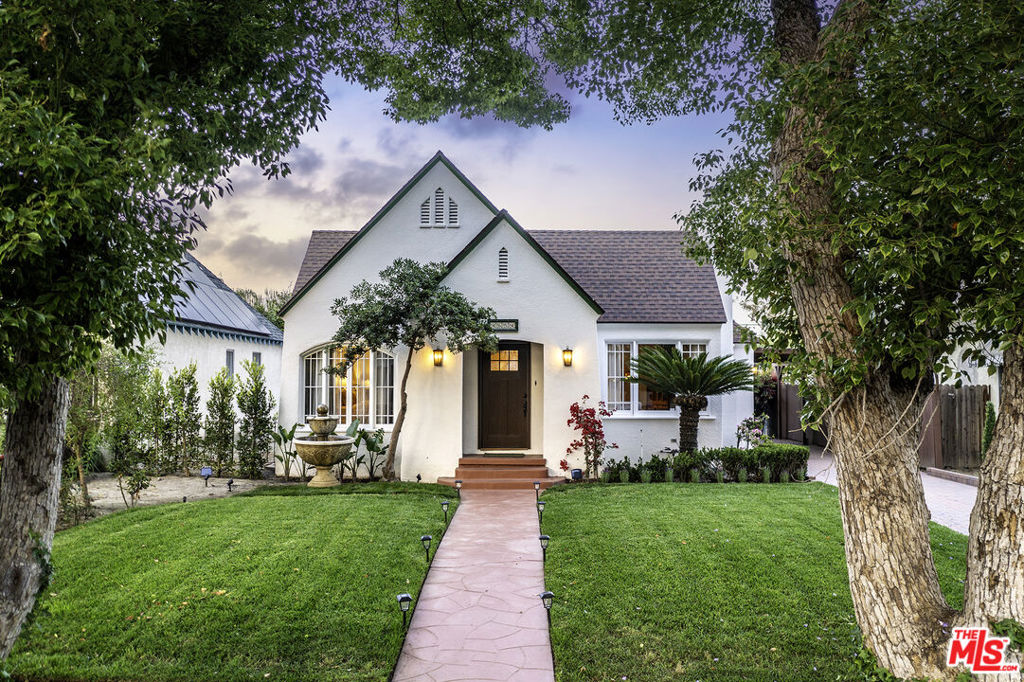 Beautifully remodeled c.1926 Tudor-style cottage nestled in the heart of Toluca Lake. 3 + 2 plus 1 + 1 guesthouse. Original details have been lovingly preserved incl. graceful arches, latch windows, built-ins, Red Oak flooring and high ceilings. Fireside living room and bright open dining room with crown molding and French doors flow to spacious cov'd brick patio--perfect when you want to move the entertaining outdoors! Modern kitchen with sophisticated muted palette, quartz tops, open shelving, gorgeous tile backsplashes and floor, refurbished vintage stove, farm sink, dining area, pantry and laundry. Main suite incl. upgraded bathroom, walk-in closet and access to patio. Bonus unfinished flex space above garage! Private entrance and separate covered patio for 634 sq. ft. guesthouse complete with carriage house doors, full kitchen, dining area, living room, and garage W/D. Brick drive to carport; approx. 7K sq. ft. lot.