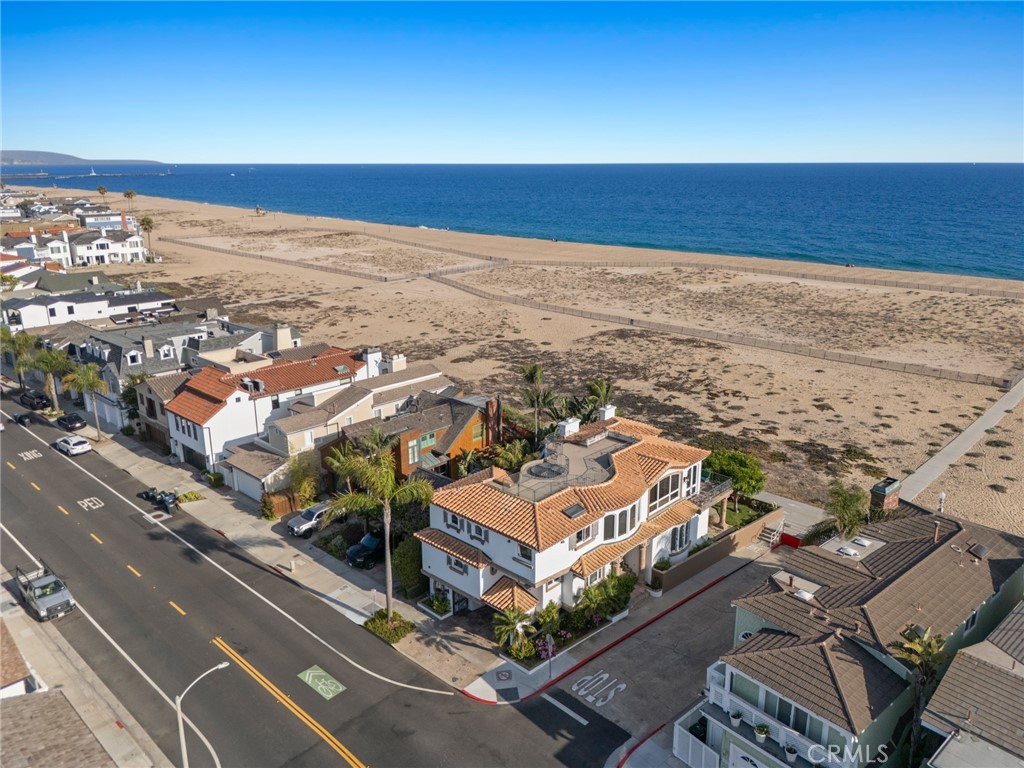 Introducing a once-in-a-generation opportunity to own a front-row property on one of the most sought-after stretches of sand in iconic Newport Beach. Perfectly positioned on a prime, oversized corner lot with 41 feet of beach frontage, this Brion Jeannette-designed home enjoys sweeping, unobstructed views of the ocean, bay, and coastline — a breathtaking backdrop for everyday living and entertaining alike. From the moment you arrive, the setting speaks for itself: panoramic vistas, the sound of waves crashing just beyond your doorstep, and a wraparound orientation that captures both sunrise and sunset skies. The floor plan offers flexibility with a main-level primary suite overlooking the sand, spacious guest accommodations as well as two additional guest bedrooms on the main level, a fourth bedroom on the upstairs/main level and an elevator servicing all three interior levels — including a rooftop deck with jaw-dropping views in every direction and a lower level wine cellar. Up the curved staircase from the entry foyer you will be greeted by an open concept living area bathed in light, with a gorgeous stone fireplace and water views at every turn. With garage and carport parking for six vehicles, this is coastal living without compromise. This is more than a home — it’s a rare chance to own an iconic slice of oceanfront in an unparalleled location.