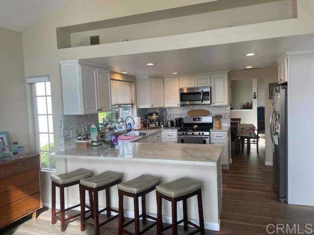 Enjoy sweeping La Costa Valley views from this highly upgraded twin home. Light and bright throughout, the two-story layout features soaring ceilings in the formal living room and a spacious, open-concept family and dining area. The downstairs boasts upgraded tile flooring, while the upstairs offers warm wood-style floors. The gourmet kitchen is equipped with stone counter tops and stainless steel appliances, including a refrigerator, and offers ample storage and prep space. The large primary suite includes a walk-in closet and enjoys stunning views of the valley. Step outside to a huge private backyard with lush grassy areas, mature fruit trees, and an expansive patio—perfect for outdoor entertaining or relaxing. Located within walking distance to award-winning La Costa Heights Elementary and just minutes from La Costa Canyon High School, beaches, shopping, and dining.