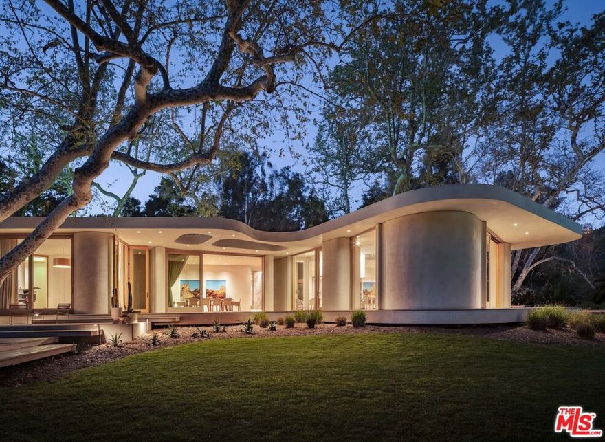 A custom-built sanctuary on over an acre in Rustic Canyon, 800 Brooktree Road's thoughtful, meticulous design surpasses all expectations. Spanning 9,708 square feet across two levels with 8 bedrooms and 6.5 baths, this home was designed by architect Bill Neburka to embrace curves, soft lines and have an inviting natural palette. Living spaces both indoor and outdoor have been crafted to maximize comfort and harmonize with the verdant surroundings. Once inside, guests are greeted with floor-to-ceiling windows framed in natural wood hues, which showcase stands of mature native trees more than 20 sycamore and coastal oaks grow on the carefully maintained property. The estate's entrance also presents hand-fired tile and an abstract sycamore installation by artist Sofia Londono, setting the stage for the home's nature-centric ambiance. Interiors by designer Jeff Guga boast soaring ceilings, wide-plank white oak hardwood floors, and soft-hued walls finished in hand-troweled Clayworks plaster. Organic materials throughout the homewood, clay and brasswere hand-selected for their warmth and durability. Custom lighting, including skylights with color LEDs, enhance the home's abundant natural light. Curated finishes include Heath floor tiles made in California, hand-crafted brass plumbing fixtures by Vola and Reveal lift and slide doors. The chef's kitchen, music room and living room (replete with 15-foot ceilings) each face a stunning grove of sycamores, while the primary bedroom overlooks a stand of coastal oaks. Outside, find expansive Alaskan cedar decks, which look out on a divine landscape designed by Jay Griffith, as well as a 60-foot saline lap pool and a standalone pool house complete with an additional bedroom and full bath. Two nearby creeks add a soothing soundtrack of flowing water throughout the year and charming frog songs in the summer. Built to last with enduring modern design and unparalleled craftsmanship, 800 Brooktree Road couples peaceful daily living with true convenience. Its ultra-private location is less than 5 minutes from the beach, Palisades Park, and the shops and restaurants of Montana Avenue and Downtown Santa Monica.