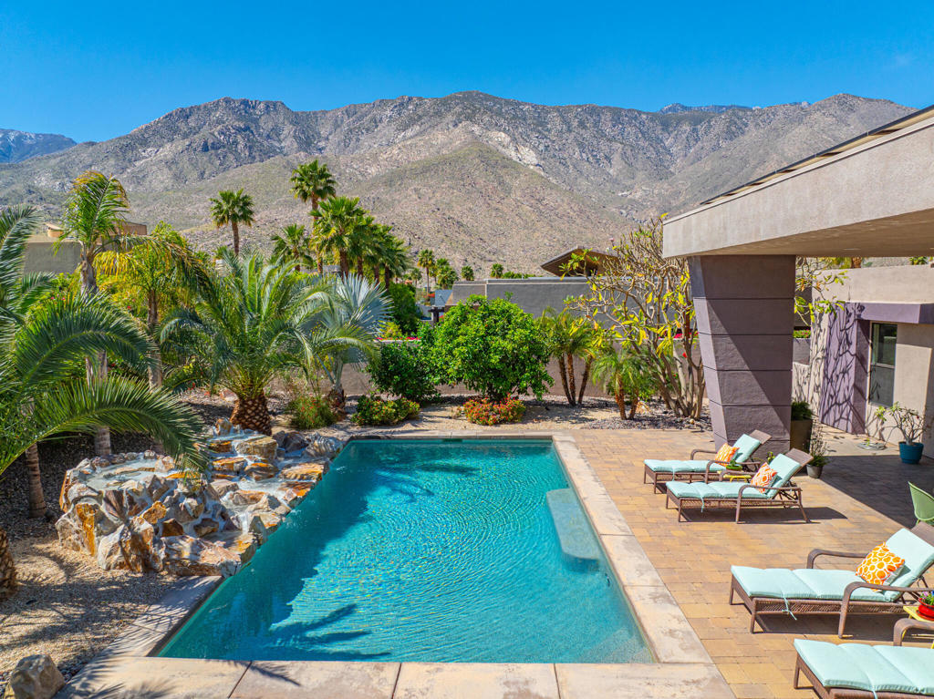 We invite you to experience a true showcase property with 3-bedrooms, 3.5-bathrooms on a coveted corner lot with south exposure at the Alta community. This 3,804 square feet traditional beauty is one of only six homes boasting a unique architectural layout, one benefit of which is the 40 x 12 covered patio in a lush garden surrounding and striking views of the mountain beyond. High ceilings and its open format lend the space a feeling of greatness and with clerestory windows and a wall of tinted windows and sliding doors, fantastic natural light. Gather by the fireplace in the expansive living area, or in the well-equipped kitchen with custom cabinetry, an enlarged island with bar seating, Wolf appliances, a walk-in pantry, and a separate bar area. Entertaining, with speakers throughout, among the many features already mentioned, make this an entertainer's dream. The primary suite is as serene as its stunning views of the pool and rock feature, featuring tall ceilings, and an upgraded bath. The saltwater Pebble-Tec pool is adorned by a striking rock feature waterfall, and additional amenities include a laundry room, dual garages with custom cabinets, and epoxy floors (3-Cars total). Large number of solar panels offer significant savings. You Own the Land! A sanctuary at the Alta awaits.