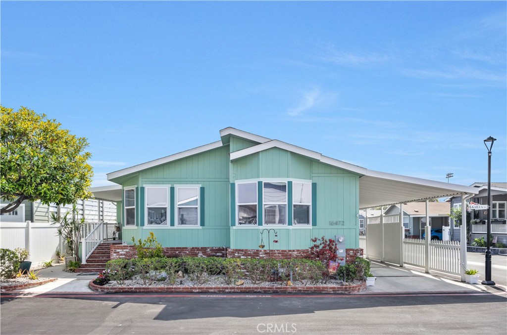 Live the coastal lifestyle just minutes from the beach, harbor, and scenic trails in this bright 3-bedroom home on a sunny corner lot. Vaulted ceilings, skylights, and a stacked stone fireplace welcome you into the open living area. The formal dining room flows into an updated kitchen with a large island, breakfast nook, pantry with roll-out drawers, and abundant cabinet space. The spacious primary suite features a walk-in shower, makeup vanity, and excellent storage. A second bedroom offers a skylight and walk-in closet. The versatile third bedroom opens to a fully enclosed porch currently used as an art studio, with access to a private rear patio—ideal for guests, work, or creative space. Additional highlights include newer luxury vinyl flooring, fresh paint, full laundry room with sink, driveway parking, and a shelved storage shed off the carport. Huntington Harbour Village is a 55+ land-owned community with a remodeled clubhouse, pool, spa, fitness room, game lounge, putting green, BBQ area, and RV parking.