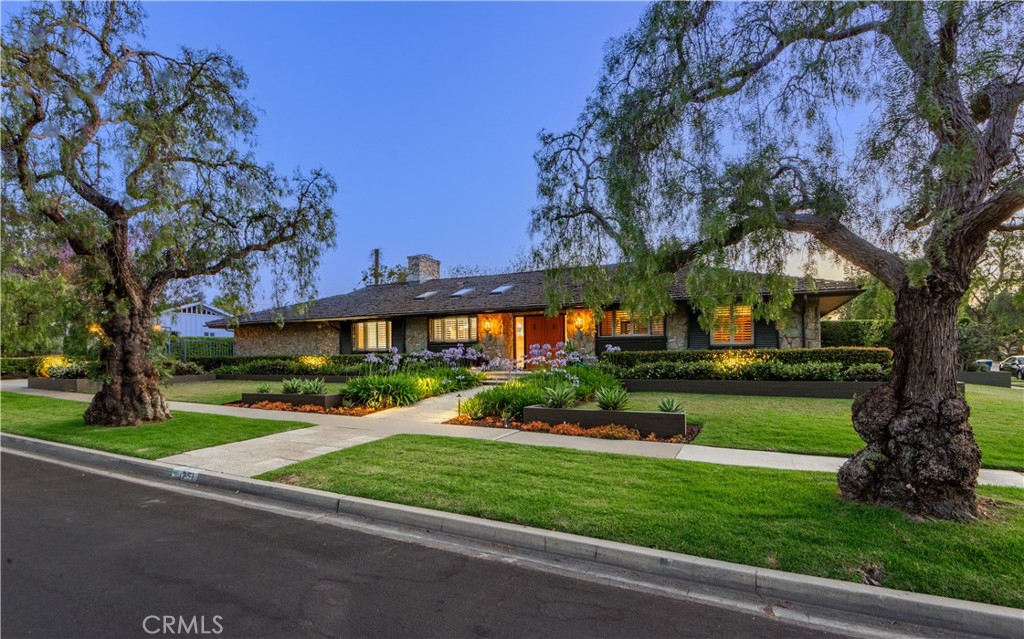 Located in the heart of Long Beach's sought after Park Estates neighborhood, 1251 Bryant Road is a sprawling single-level mid-century modern ranch style home sited on a large 10,375 SF lot. Designed by architect Raymond A. Sites— this home, which he referred to as Villa Verde, is a testament to his visionary approach to architecture. Positioned on a prime, interior corner lot, the custom residence boasts exceptional curb appeal with a beautifully landscaped front yard. The residence features 3 bedrooms plus a home office, 3 bathrooms, and 3,072 sq. ft. of living space. The home’s striking Palo Verde stone façade, mahogany doors and accents, and oak flooring provide a warm, timeless appeal. The expansive 30-foot great room with vaulted, beamed ceilings and generous use of windows and sliders is at the center of the home. Gourmet kitchen is equipped with high-end appliances, an extra-large island, casual eat-in dining area, workstation, and is open to the family/great room. Separate den with stand behind bar adds a delightful sophistication. The primary en suite offers a private retreat, complete with a cozy fireplace, updated bathroom, and two walk- in closets. The additional two bedrooms are spacious with upgraded hall bathroom. There is a wonderful indoor laundry room and separate mud room. The Napa inspired backyard is equally impressive featuring a beautiful slate patio with thoughtful lighting, stone planters, and an outdoor kitchen with grill and smoker—perfect for al fresco dining. Covered patio/loggia space, fireplace, spa, and water wall feature providing an organic and peaceful and relaxing feel. The large lot offers tons of space for enjoying the outdoors with grassy areas and mature trees that add privacy and beauty. There is an elegant gated driveway and attached garage. Living in Park Estates the residents enjoy the beautiful tree-lined streets, wide lots, and tight-knit community. Minutes from Alamitos Bay, this residence is ideally situated to enjoy the best of both worlds: neighborhood living with convenient access to the nearby beaches. Top-rated schools, local amenities, numerous golf courses, and local parks. Nearby Alamitos Bay offers watersports, kids camps, SUP, boating and sailing. Nearby Seal Beach with its charming Main Street and scenic pier. Centrally located to LA, the South Bay, and Orange County. 1251 Bryant Road is a rare opportunity to own a piece of architectural history in one of the area's most sought-after communities.