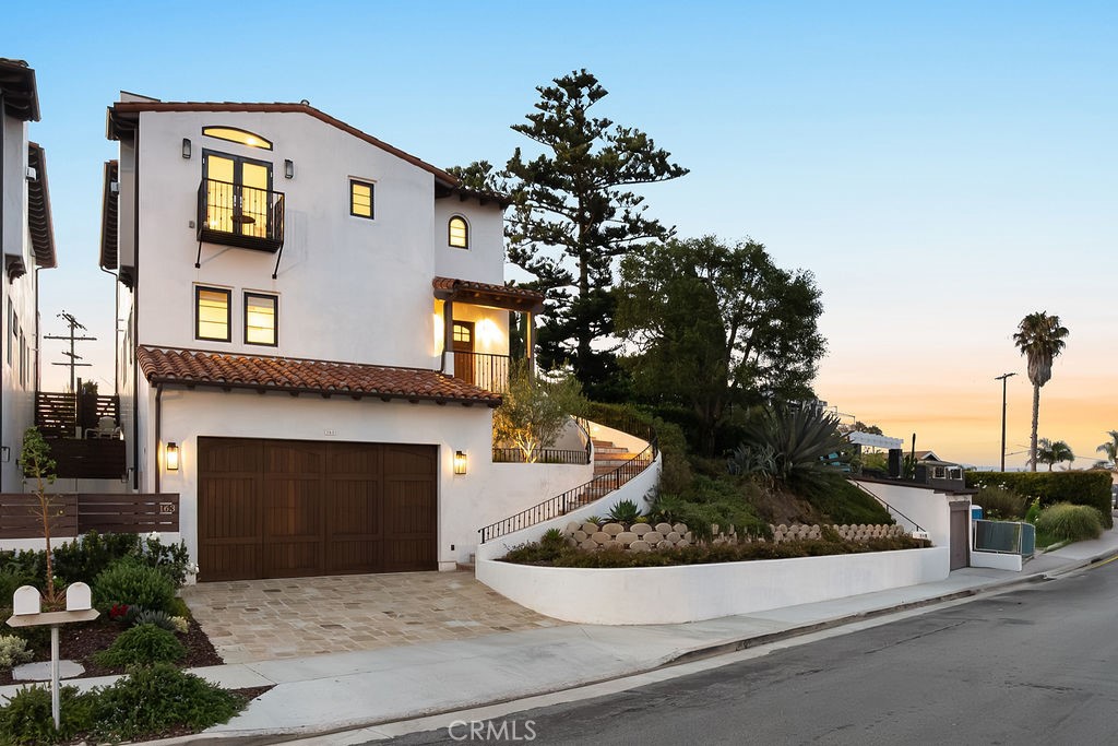 Bursting with character and coastal charm, this Spanish-style smart home in San Clemente offers luxury living in a prime location. Built in 2020, the residence features beautifully terraced landscaping and a dramatic staircase leading to the front entry. Inside, vaulted ceilings, a neutral palette, and French Oak hardwood flooring create a sophisticated ambiance. The spacious living room is anchored by a striking fireplace and custom bar—perfect for entertaining. Glass sliders in the dining area open to an ocean-view terrace ideal for indoor-outdoor living. The chef’s kitchen is equipped with top-tier stainless steel appliances, built-in Sub-Zero refrigerator, white cabinetry, quartz countertops, and a large island with pendant lighting. All bedrooms are generously sized, offering ceiling fans, ample closet space, and a shared bath with a shower/tub combo. The luxurious primary suite provides direct backyard access and a spa-inspired ensuite featuring dual vanities, oversized walk-in shower, freestanding tub, and custom walk-in closet. Outdoor living is elevated by stunning ocean and Catalina Island views. Host guests on the sun-drenched terrace with a built-in Twin Eagles Pellet Grill or relax in the secluded backyard, complete with a covered pergola, dramatic fire pit, and oversized spool with a waterfall feature. Additional highlights include a laundry room near the bedrooms, elevator access on all levels, owned solar panels, EV charger, and an oversized 4-car garage with 12'4" ceilings—ideal for installing a car lift. Located just minutes from downtown San Clemente, popular shops, restaurants, breweries, and beach access, this home blends comfort, style, and convenience in one exceptional package.