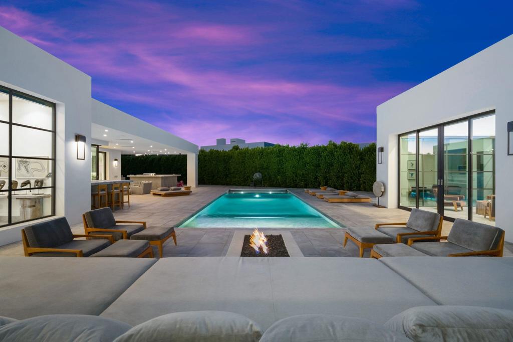 Warm contemporary compound perfectly situated on the Madison Club's famed Ross Avenue featuring the only private pond and beachfront view. No golf courseor cart access creates the ultimate privacy like no other home at the Madison. This stunning residence exudes coastal Santa Barbara aesthetics by an acclaimed designerfor its exclusive owner. A smart floor plan with a spectacular oversized kitchen/family area with massive double islands and dramatic vaulted ceiling and recedingautomated walls of glass all open to a sprawling backyard with views of the lake and to a private swimmer's pool. Two beautiful casitas: one with two en suite bedrooms withden and kitchenette and one with private outdoor access. Multiple loggias, lounging areas and an extensive outdoor kitchen with BBQ area and an extra large gated andprivate motor court with an oversized 4-car garage. Master retreat with a fabulous bath and shower, walk-in closet and a private outdoor shower. Massage area/living room,private gym with views, office space and two en suite bedrooms with a center den/playroom and state-of-the-art theater. This is a rare opportunity to own a stylish familyresort next door to the largest, newest and most substantial estates in the club.