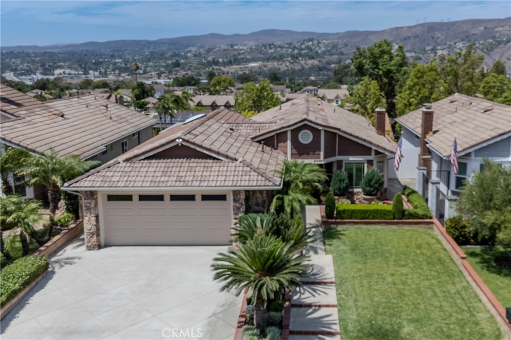 This stunning single-story home is the best in Anaheim Hills at this price point. Wonderful curb appeal, luxurious upgrades throughout and city lights and hillside views. Spanning over 1,500 square feet, the three-bedroom, two-bath layout has been thoughtfully expanded to create an open and inviting floor plan. At the heart of the home is a true gourmet kitchen featuring a custom island with prep sink, five-burner gas cooktop, and abundant storage. Included are Thermador double ovens, warming drawer, microwave, French door refrigerator, and a brand-new Bosch dishwasher. A dining nook and lots of additional pantry space complete the kitchen, which seamlessly flows into the spacious great room. The great room includes custom built-ins with a TV, and patio door highlighting the view. The living room showcases a marble-tiled fireplace and opens to the formal dining area. Wide-plank flooring throughout, plantation shutters, upgraded dual-pane windows, and beautifully remodeled baths elevate the interior. Each bedroom includes a designer closet with custom built-ins, adding both function and style. The home also comes with a new washer and dryer, new water softener, garage cabinets, a newer A/C and furnace, and a whole-house fan. Set on a quiet street, this home also offers a two-car attached garage with insulated door, low HOA dues of $77 per month, and a low property tax rate of approximately 1.05%. Conveniently close to shopping and dining, this residence is move-in ready and represents Anaheim Hills living at its finest.