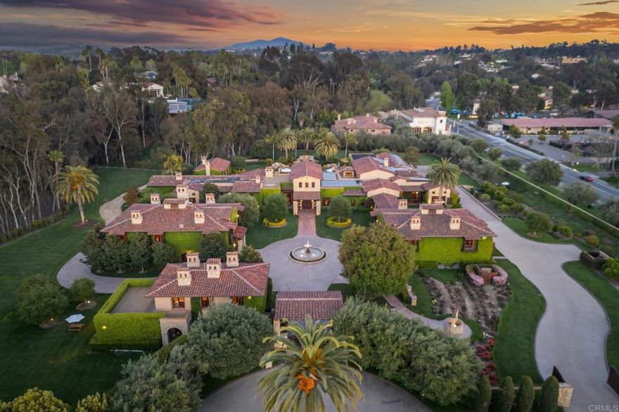 This Magnificent Compound is a one-of-a-kind Village estate set on nearly 5 fully usable, walled and double gated acres in Rancho Santa Fe. Designed and built by Sylvester Construction, this private compound offers over 20,000 sq ft of refined living space across four separate buildings, including 10+ bedrooms, 17 bathrooms and unmatched resort-style amenities. The main, single level, residence features 5 ensuite bedrooms, dual his-and-her master bathrooms with extra large walk in closets and a private outdoor area with a waterfall, formal living and dining rooms, a cherry wood paneled study, music and game rooms opening to a wine bar and climate controlled wine cellar, his and her offices, and an expansive family room with disappearing lift and glide doors that recede into the wall for seamless indoor/outdoor living. The Chef's kitchen has high end Viking appliances, four Viking ovens, a Sub-Zero refrigerator, walk in pantry and a vast center island.    Additional structures include a private theater house with a coat check, full snack and drink bar and game room, a 2-story collector’s showcase building with a full gym (or fits 10 cars) and a 3 bedroom guest house upstairs, plus a detached 2BR guest house with an office and attached 2 car garage.    The gym was originally built to be a high end barn and could easily be converted. There is plenty of space for a large corral and jumping area. Trails can be accessed from the property for long trail rides.   Outdoors, enjoy a resort style pool with multiple waterfalls, two covered cabanas with wood burning fireplaces, an outdoor BBQ area, and tranquil courtyards surrounded by lush, mature landscaping. The entire property is run by paid solar including the pool. Inspired by ancient Italian villas and Tuscan design, this opulent estate offers total privacy, high-end finishes, and Southern California luxury at its finest.
