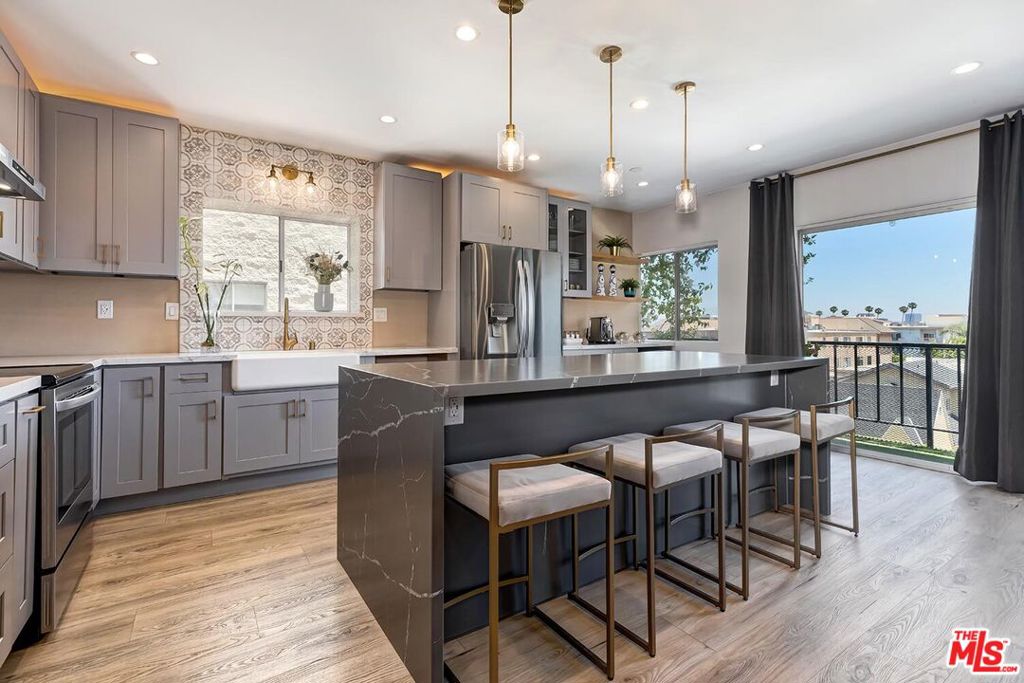 This beautifully renovated condominium with incredible views underwent a comprehensive, high-end remodel completed in August 2023. Every element was thoughtfully selected to enhance comfort, functionality, and modern appeal throughout the home. In an amenity-filled building, features a rarity for the complex... in-unit laundry! Enjoy the tasteful details of the Living Room, Eat-in-Kitchen with wine/coffee bar and enjoy the views of the beautiful city and Hollywood Sign from your expansive kitchen island or the patio. Both bathrooms, the hall bath and the Primary, have been remodeled, including the brand new soaking tub with glass door and waterfall shower head. Primary suite also includes an impressive walk-in-closet. Sought after building includes a list of impressive amenities, including year-round heated pool and spa, fitness room with sauna, recreation room and external storage for unit and provides Earthquake Insurance. Across the street from Beverly Hills and a block from Beverly Drive provides an easy access to restaurants, cafes, grocery stores and commuter routes. Don't miss out!