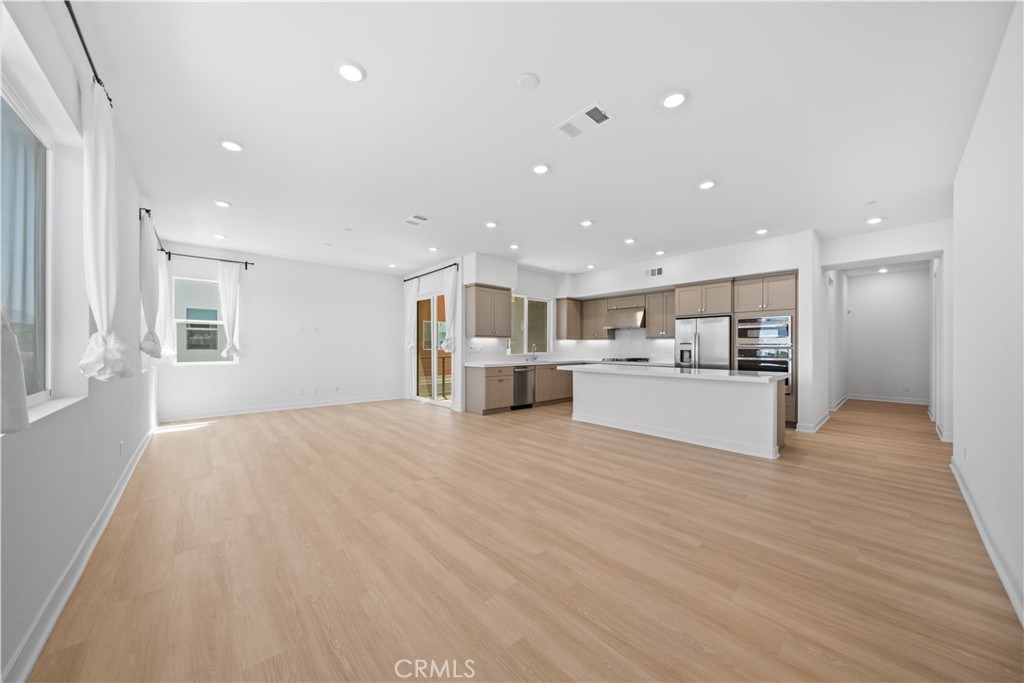 Welcome to this thoughtfully designed tri-level townhome in a prime Irvine location—just steps from the award-winning Portola High School! This spacious and functional layout offers 3 bedrooms, 3.5 bathrooms, and a versatile loft space, perfect for a home office or additional family room. The first level features a convenient two-car attached garage, complete with a Tesla EV charger for effortless daily charging.. As you head upstairs, the second floor welcomes you with an open-concept living room, dining area, and modern kitchen, seamlessly connected to a cozy balcony—ideal for relaxing or entertaining. This level also includes a private ensuite bedroom and a powder room for guests. The main entry door from within the building also opens to this level for added accessibility. The third floor showcases a bright loft area with a second balcony, a generously sized primary suite, and an additional secondary bedroom and bath. As a bonus, an extra private storage room is conveniently located directly across from the main entrance—perfect for seasonal items, sports gear, or luggage. Enjoy additional peace of mind and long-term savings with a fully paid-off solar system. Best of all, Portola High School is directly across the street—a one-minute walk to one of Irvine’s top-rated schools! Whether you're a first-time buyer or a young family starting out, this home offers exceptional value in one of Irvine’s most desirable Great Park community. Enjoy all the amazing amenities of the Great Park Neighborhoods, including its parks, clubhouse, heated pools, hot tubs, sports courts and fields, playgrounds, and picnic areas. Don’t miss this rare opportunity to own a stylish and affordable home in an unbeatable location!