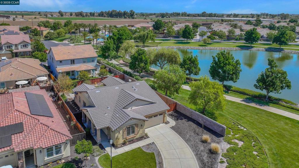 Welcome to this one-of-a-kind single-story 3BD/2BA home in the gated Discovery Bay Lakes community with 24/7 security, set on a rare 8,276 sq ft corner lot just steps from the lake. Built in 2014, this turnkey home features luxury vinyl plank flooring and tile throughout, an open-concept layout ideal for modern living. The chef’s kitchen includes a large island with countertop seating—perfect for casual dining or enjoying the action—plus a butler’s cabinet for added storage. The spacious primary suite offers a walk-in closet, sunken tub, double sinks, and abundant natural light. Outside, unwind in your mini California room with TV and fireplace, or relax in the landscaped yard with stamped concrete. Parking includes a long driveway, near designated guest spaces, and gated side access for RVs, boats, trailers, or car collectors. Additional upgrades: whole-house water softener, dechlorination system, reverse osmosis, and Nest thermostat with remote control. Enjoy peaceful lake trails and resort-style living in this secure, sought-after community.