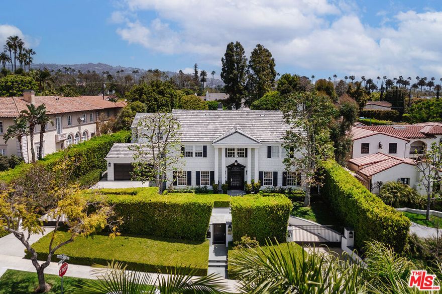 Step into an exquisite blend of classic East Coast charm and contemporary luxury in the Beverly Hills Flats. This stunning estate has been meticulously remodeled to offer elegance, comfort, and functionality. The stately gated residence features a classic shingled facade, a columned two-story entry, and a crescent-shaped motorcourt. Inside, the striking foyer with a sweeping staircase sets the tone for sophisticated interiors. Herringbone hardwood flooring, marble fireplaces, and artisan cabinetry blend traditional craftsmanship with modern design. The main level offers a seamless flow between grand and intimate spaces, ideal for both entertaining and everyday living. Sophistication radiates from the formal living and dining rooms, while the wood-paneled library and billiard room create cozy retreats. At the heart of the home lies the family room, conveniently adjacent to the chef's kitchen, making it perfect for movie nights. This culinary dream space is equipped with professional-grade appliances, handcrafted cabinetry, a charming breakfast nook, and an adjoining family room.Designed for indoor/outdoor entertaining, the expansive backyard includes a saltwater pool, spa, BBQ area, and sport court for pickleball and basketball. For those who work from home, a front office with a separate entry and an additional office space in the master bedroom offer convenience and privacy.The home's upper level features the magnificent primary suite with dual bathrooms, dual walk-in closets, and a balcony overlooking pine trees and manicured grounds. Four additional ensuite bedrooms ensure ample space for family and guests. The estate also includes a charming guesthouse, modern amenities such as a full backup generator, security gate, and cameras, and an oversized carport with four covered parking spaces. This is more than just a home; it's a statement of refinement and style. Move-in ready and thoughtfully designed, it invites you to experience the epitome of luxury living in Beverly Hills.