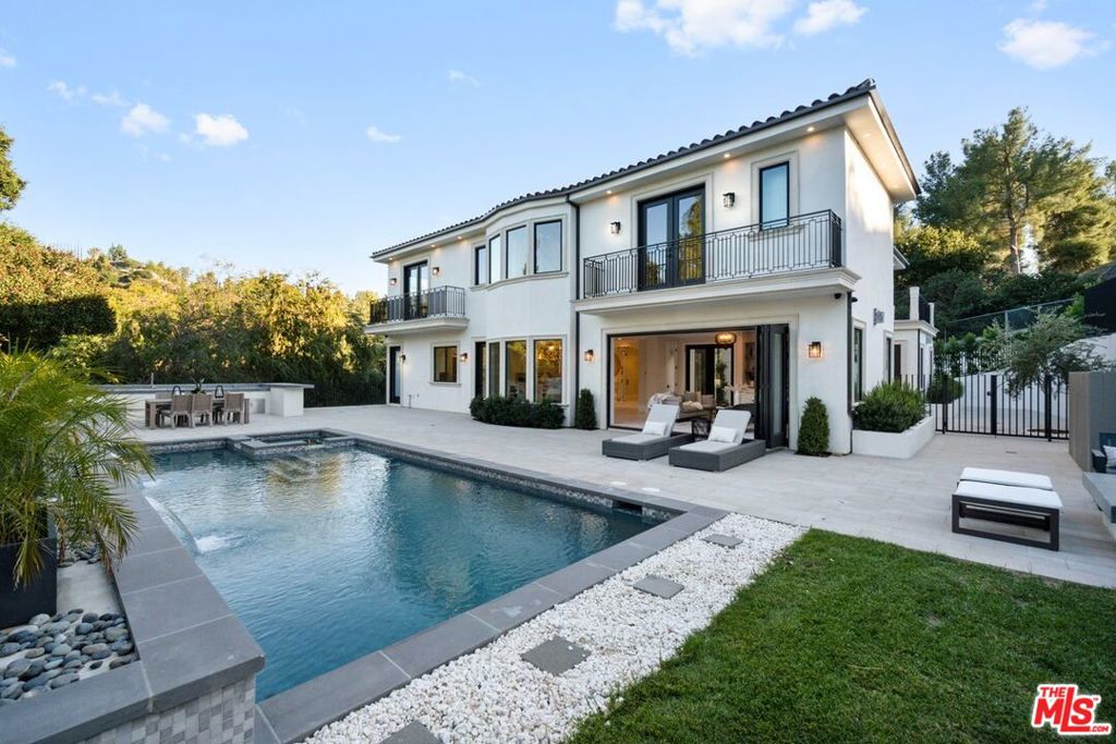 Brand-New Custom Estate | Tarzana's Crown Jewel Experience the pinnacle of luxury living in this newly constructed custom estate, perfectly situated in one of Tarzana's most coveted enclaves. Privately set behind a gated driveway off Vanalden Ave, this 5-bedroom, 8-bath architectural masterpiece seamlessly blends timeless elegance with cutting-edge design. Step inside to soaring coffered ceilings, natural light streaming through oversized windows, and a fluid floor plan designed for both grand entertaining and intimate moments. At the heart of the home lies a stunning glass-enclosed wine cellar, anchoring the formal dining and living rooms with dramatic flair. The living room's stately fireplace opens to a tranquil courtyard, while the expansive family room connects to a breakfast nook and chef's dream kitchen outfitted with Sub-Zero and Wolf appliances, a statement quartz island, and panoramic views of the resort-style backyard. Disappearing walls of glass create effortless indoor/outdoor flow, leading to a backyard paradise with a sparkling pool, cascading waterfalls, spa, fire pit, and a fully equipped BBQ station with its own dedicated bathroom. A spacious guest suite, powder room, and laundry room complete the main level. Upstairs, four additional en-suite bedrooms await, including a show-stopping primary suite with vaulted ceilings, fireplace, and tree-framed views. The spa-like primary bath features a soaking tub with peaceful vistas, a generous walk-in closet, and dual balconies overlooking the valley. A light-filled library/study area adds a touch of functionality to the upper floor. Downstairs, indulge in a private media theater, gym/game room, and an additional bath perfect for work-from-home or guest privacy. The property includes a 3-car garage along with ample outdoor space for up to 12 additional vehicles, offering parking for 15+ cars and potential RV accessideal for entertaining on a grand scale. Currently nearing completion, this estate represents the finest in Southern California luxury detail, meticulously curated for comfort, beauty, and lifestyle.