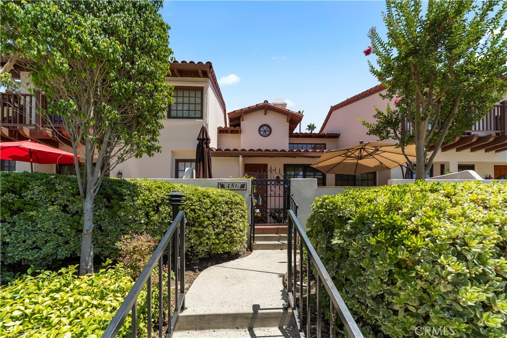 Welcome to 456 E Bougainvillea Lane, a charming multi-level townhome nestled in the highly desirable gated community of Rancho del Bougainvillea in North Glendora. This well-maintained 2 bedroom, 2 bathroom home offers a unique tri-level layout with flexible living spaces and inviting charm. Step through the front door into the main living area featuring a cozy fireplace, vaulted ceilings, and an abundance of natural light. The spacious dining area flows into a well-appointed kitchen, while a full hallway bathroom and guest bedroom—complete with private balcony access—offer comfort and functionality on the main level. Downstairs you'll find direct access to the oversized two-car garage, as well as a den with built-in shelving and a closet that houses the in-unit washer and dryer—ideal as a home office, studio, or flex space. The top level is reserved for the private primary suite, which boasts high ceilings, a walk-in closet, and a spacious en-suite bathroom with dual sinks, a soaking tub, separate shower, and dedicated vanity space. Enjoy warm Southern California days on the front patio or at the beautifully landscaped community pool and hot tub area. With gated entry, lush grounds, and proximity to the foothills, downtown Glendora Village, and award-winning schools—this home offers both tranquility and convenience.