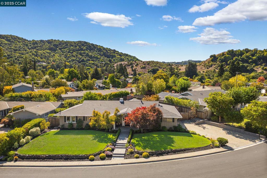 Set on a 13,000-square-foot lot in Moraga’s desirable Camino Woods neighborhood, this beautifully maintained single-story home blends timeless design with modern comfort. A formal dining room opens to a living room with elegant millwork, fireplace, and abundant natural light. The kitchen features a center island, Thermador gas range with griddle, built-in refrigerator, and a breakfast nook framed by bay windows overlooking the backyard. The family room includes custom built-ins and opens outdoors, ideal for entertaining or everyday living. The primary suite offers dual closets, direct yard access, and a spa-like bath with a jetted tub, dual shower, and double vanity. Two additional bedrooms share a spacious hall bath. Additional highlights include a finished garage, recessed lighting, and crown molding throughout. Outside, enjoy an outdoor kitchen with built-in pizza oven, lawn, hot tub, and patio designed for gatherings. Close to top-rated Camino Pablo Elementary, Joaquin Moraga Intermediate, and Campolindo High, with easy access to Orinda BART, Highway 24, and Moraga Center’s shops, cafés, and farmers market.