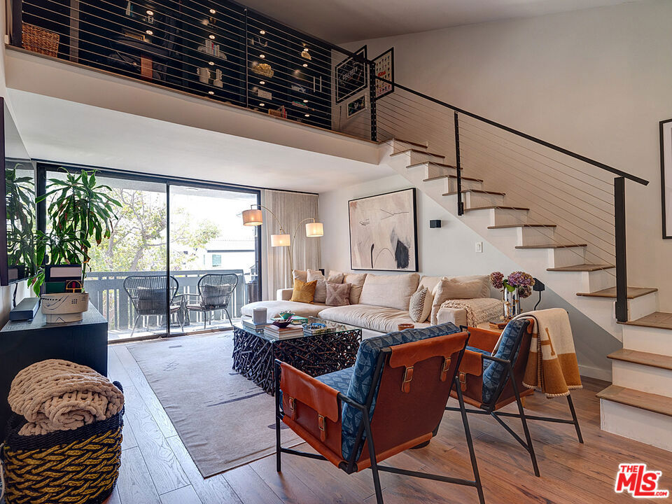 This stunning 3-bedroom, 3-bathroom condominium offers over 2,000 sq. ft. of beautifully remodeled living space in a top-floor, west-facing unit with an exceptional single-story layout and bonus loft. Every detail has been thoughtfully reimagined with a crisp, contemporary aesthetic. The spacious living room boasts 17-foot ceilings, a gas fireplace, and sliding glass doors opening to a private balcony with unforgettable sunset views. A bonus loft with custom built-in bookshelves provides the perfect setting for a home office, library, or creative retreat. The well-appointed kitchen features white quartz countertops, stainless steel appliances, shaker cabinetry, and open shelving, flowing seamlessly into the dining area. A convenient powder room off the dining space makes entertaining effortless. Three generous bedrooms include a luxurious primary suite with west-facing views, an expansive walk-in closet, and bonus storage space. A full hall bath serves the additional bedrooms, while white oak wood floors throughout add warmth and style. The home is complete with a full-size washer and dryer inside the unit for convenience. Additional features include three deeded parking spaces in a gated garage with EV charging and an immense amount of dedicated storage space. Building amenities include a rooftop deck with pool and spa, surrounded by panoramic views of Century City, Westwood, and beyond. Just minutes from the restaurants, shopping, and entertainment of Westfield Century City, this home is also located within the sought-after Westwood Charter Elementary School district.