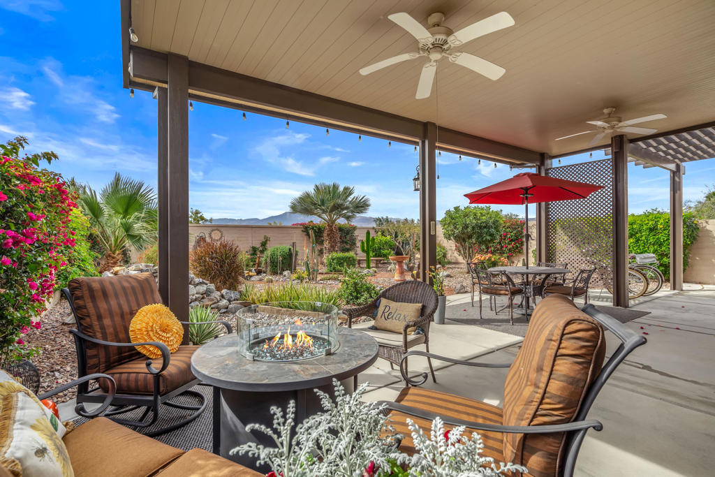 Beautifully appointed and popular Montoya plan in Sun City Shadow Hills C.C. This TURNKEY FURNISHED 2 bedroom, 2 bath PLUS DEN home (den being used as bedroom 3) features a leaded glass entry door with Invisa screen, plantation shutters, slab granite kitchen counters, stainless steel appliances, pendant lighting, custom built-in shelving in the eating area, crown moldings, tall baseboards, large diagonal tile and luxury vinyl flooring throughout. The oversized SOUTH FACING rear yard with extensive concrete decking and sidewalk has attractive low maintenance desert landscaping and plenty of room for entertaining or to add your own pool. It also features an extended solid aluminum patio cover with fans, lighting and outlets which provides ample room for lounging and taking in the great mountain views! Additional features include, recent inside & outside painting, new mirrors and lighting in the bathrooms, Tankless water heater, laundry sink, surround sound speakers, LED lighting, designer ceiling fans and loads of garage storage cabinets and hanging racks. A real gem of a find and located in Sun City Shadow Hills popular and sought after Phase 3.