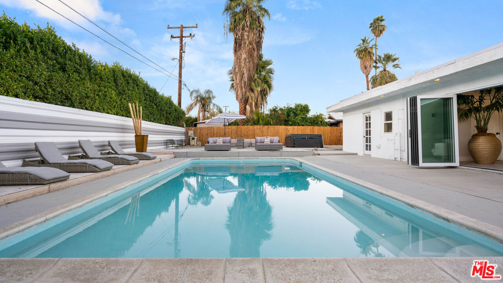 Incredible Opportunity, no HOA or Land Lease - you own the land. Owned Solar system! Short-term rental ok! Welcome to your desert sanctuary located just minutes from downtown Palm Springs in Demuth Park. This stunning fully furnished, turn-key home has been completely upgraded and remodeled offering a seamless blend of mid-century design and desert charm. The updates include a new kitchen, bathrooms and paint making it move-in ready! The open kitchen is a culinary haven, complete with new black and chrome appliances flowing into the living room which opens with huge sliding doors to the private back yard featuring a sparkling pool, expansive deck and and spa area - perfect for outdoor entertaining. Retreat to the luxurious master suite or two guest bedrooms, all with French doors opening to the outdoor oasis. The home also features a bonus room off the kitchen, perfect for a home office or gym. The detached air conditioned garage is an additional bonus space the could be used as a pool room. Featured on a large fenced and gated lot with ample parking and space for an RV. Located in a prime and tranquil neighborhood, close to the airport and all the sports activities Demuth Park has to offer including pickle ball, tennis, walking trail sand playgrounds. This is the perfect home for a successful vacation rental, primary residence or second home. Schedule your showing today and experience desert living at its finest.