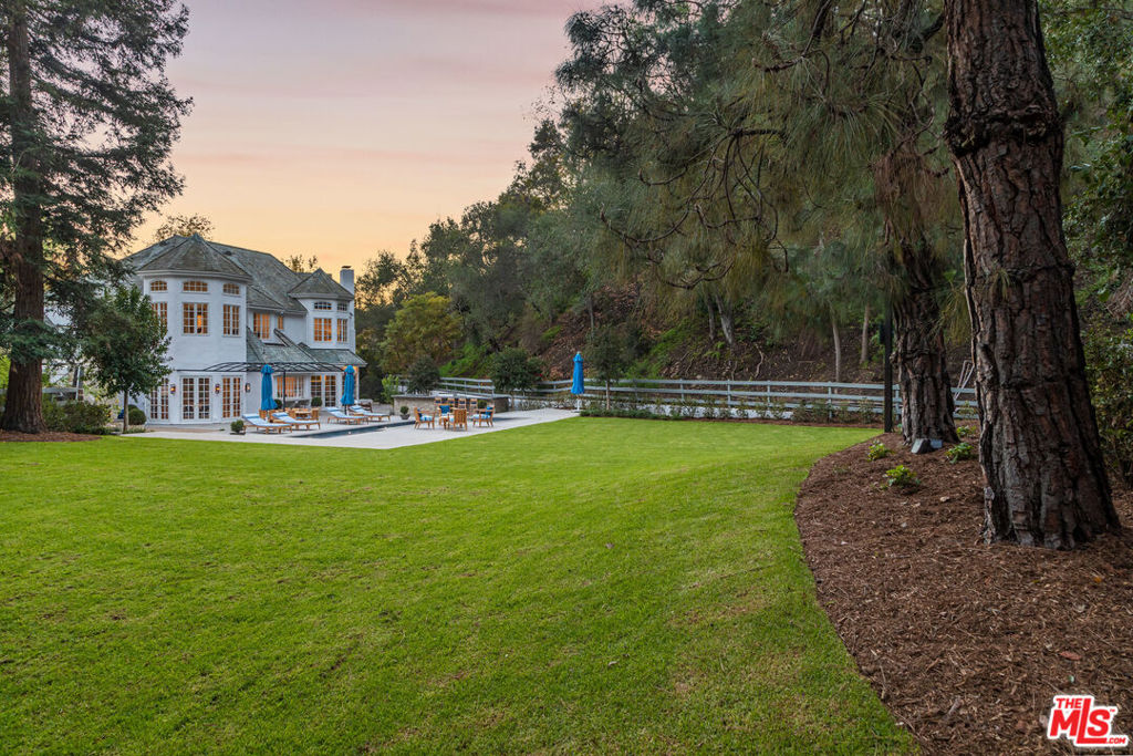 Newly renovated, move-in ready estate on one of the most secluded streets in Los Angeles. Set on 3.1 acres in lower Mandeville Canyon, this country English traditional is gated and landscaped for total privacy and absolute serenity. Custom-designed finishes and woodwork highlight an open yet intimate floor plan that exudes volume and scale in every room. The formal entrance is a stunning two-story foyer with black & white marble and limestone tile framed by a white oak, quarter-turn staircase with custom designed steel & brass handrails. The ground floor showcases a formal living room, 2 elegant powder rooms, dining room, family room with 4-seat bar, wood paneled office or media room, chef's kitchen with butler's pantry and breakfast room, and 2 en suite bedrooms. The second floor boasts an expansive and lavish owner's wing with separate bathrooms, separate boutique walk-in closets, and office or nursery, and 4 additional en suite bedrooms. 10 French doors open to a rolling front lawn and a sweeping back lawn with breathtaking canyon views. A blue-tiled 40-foot pool & spa and limestone barbecue & 8-seat bar complete an entertainer's paradise. Additional luxe features include Crestron smart home system, Lutron lighting, state-of-the-art security system, laundry rooms on both floors and a separate entrance for staff and service. This rare and countryside setting is only minutes from Brentwood, Santa Monica & Pacific Palisades. Additional photos and property website available upon request to qualified buyers and their agents.