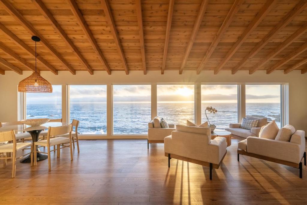 Perched above Otter Cove with panoramic views in the exclusive gated enclave of Aurora Del Mar, this oceanfront retreat offers unmatched privacy, relaxed coastal living, and rare direct beach access. One of just 18 homes in this coveted Carmel Highlands community, the 2,906 sq ft residence showcases timeless Santa Barbara-style architecture on a full acre of prime coastal land. The open-concept layout features vaulted ceilings, expansive windows, and Ipe wood decks, inviting seamless indoor-outdoor living, enjoying unobstructed views from Big Sur to Yankee Point. The reverse floor plan places the oceanview primary suite on the main level with dual walk-in closets, a spa-like bath, and private deck. Two additional guest suites are located downstairs with direct outdoor access. Interiors by SFA Design blend coastal elegance with comfort, highlighted by an oceanview kitchen with Sub-Zero appliances, two fireplaces, wet bar, wine cellar, and more. Just minutes from Big Sur, Point Lobos, and all the incredible amenities on the Monterey Peninsula, this rare legacy estate embodies the best of California coastal living.