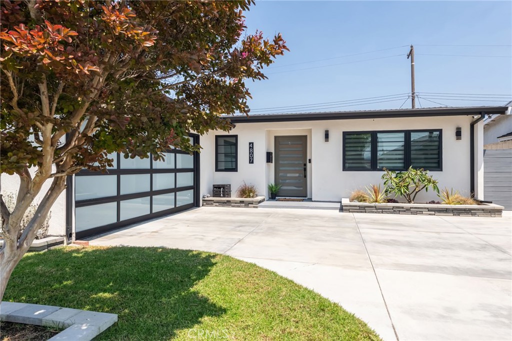 Tucked away on a quiet street in the heart of West Torrance, this meticulously remodeled Mid-Century Modern ranch home blends timeless design with high-end contemporary upgrades, creating a stylish retreat with no detail overlooked.
It’s clear this home was reimagined with intention. The open-concept living space is anchored by a sleek 72” electric fireplace, framed by clean lines and natural light pouring in. Luxury vinyl wood flooring stretches throughout, providing a cohesive flow that leads you into the show-stopping kitchen — a true centerpiece of the home. Outfitted with black stainless steel appliances, including a 36” Z-Line 6-burner gas range with electric oven, Samsung Family Hub smart refrigerator, wine fridge, and microwave, this kitchen was designed for both function and form. Marble countertops, an oversized island perfect for gathering, a Kohler farmhouse sink, and under-cabinet lighting elevate the space even further.
Both bathrooms are curated with spa-like sophistication. The hall bath features Kohler fixtures, a light-up mirror, custom shower door, and soaking tub. The primary suite is a serene escape with a spacious walk-in closet (plus a bonus closet), and a magazine-worthy ensuite bath. Here you’ll find an extra-large frameless shower with upgraded glass, a deep stand-alone Kohler tub, double vanity, illuminated mirrors, and an Ove bidet toilet with all the tech-forward comforts.
Step outside to a private backyard that stuns at sunset, complete with a gas fireplace and views that stretch to downtown Los Angeles. It’s the perfect space to unwind or entertain under the glow of Govee smart eave lighting — festive all year round.
This smart and secure home includes a Ring doorbell camera, four Reolink outdoor surveillance cameras with DVR, a data cabinet with CAT6 and RG6 wiring to every room, and a brand new electrical panel and sub panel in the garage. Additional upgrades include a new AC and heating system, tankless water heater, sleek black gutters, and all-new Anderson windows and doors throughout.
Every finish, fixture, and feature in this home was thoughtfully selected to offer elevated living with a nod to classic mid-century charm — all in one of the South Bay’s most beloved neighborhoods.