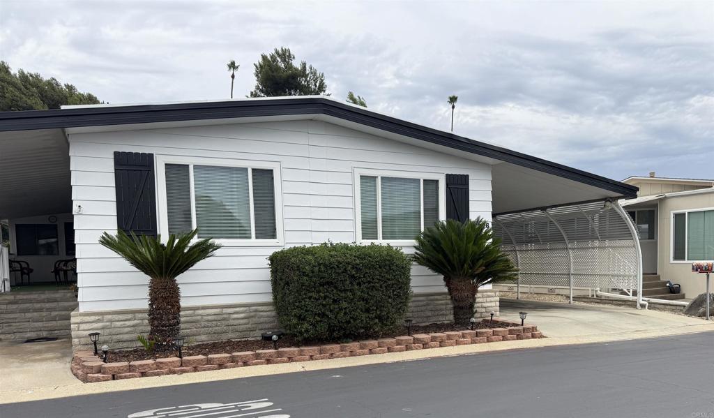 I would like to present a beautifully maintained double-wide residence situated on a spacious corner lot. This home is located in the sought after 55+commuity of Madrid Manor in San Marcos. It features numerous upgrades and amenities, including wood-look laminate flooring throughout, newer kitchen appliances, two skylights, and a newer roof. The water heater has also been recently replaced by the sellers. The main suite offers a walk-in closet and a walk-in shower. Additionally, there is an 8 x 18 California Room, providing versatile extra space ideal for an office or craft area. The property also includes an extended carport with additional guest parking, conveniently located adjacent to the main guest parking area. Residents will also benefit from the many park amenities and activities available for their enjoyment.