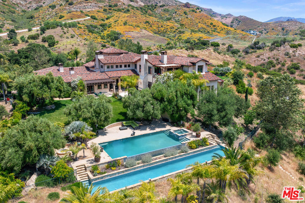 Timeless Tuscan masterpiece set behind the gates of the prestigious Lobo Canyon Estates. This 7637 sq ft home spans over nearly 50 acres of private and picturesque land, perfect for ranching, equestrian pursuits and outdoor recreation with countless trails to explore. Complete with its own underground water well and resort-style grounds, the home features tiered pools, an endless exercise spa, a seasonal creek with mature trees, manicured gardens and parking for more than 20 cars, all just minutes from Malibu. The estate offers several primary suites with private elevator access and serene garden balcony views, soaring ceilings with oversized windows, multiple fireplaces, formal living and dining rooms, a wine cellar, gym, sauna, and a spacious open-concept kitchen perfect for large-scale entertaining or just showcasing your culinary skills at home with friends. A rare estate offering and an opportunity not to be missed.