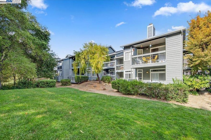 Beautifully maintained 2-bedroom, 2-bath lower-level condo filled with natural light and peaceful views of trees and greenbelt. The inviting layout features tile flooring upon entry and throughout the living room, kitchen, and dining nook. A marble bar counter, cozy fireplace, and sliding door to the outdoor patio make it ideal for relaxing or entertaining. The updated kitchen offers newer countertops, marble backsplash, polished metal pendant light, bay window, pull-out drawers, double-door pantry, and quality appliances including a KitchenAid induction range, Bosch dishwasher, and GE refrigerator. Hallway laundry closet includes newer washer and dryer. Guest bedroom features a Murphy bed with shelving (included). Engineered hardwood floors in hall and bedrooms, updated bathrooms with tile floors and Hall Bath includes a spacious walk-in shower. Primary suite has walk-in closet, en-suite bath, and private patio. Includes 1 car detached garage plus 1 parking space. Close to freeways, BART, shopping, and restaurants. HOA includes water, waste, and resort-style amenities: two pools, spa, tennis, basketball, sand volleyball, gym, clubhouse, and greenbelts.