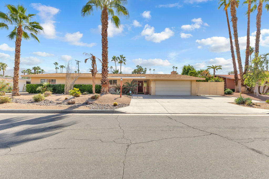 This classic mid-century ranch home blends timeless desert architecture with spacious modern living, perfectly situated near El Paseo's upscale shopping, dining, and entertainment. Featuring 4 bedrooms, 3 bathrooms, and approximately 2,757 sq. ft., the residence offers generous living areas and authentic character throughout.A formal living and dining room set the tone for elegant gatherings, while the expansive great room impresses with wood-beamed ceilings, abundant natural light, and a seamless connection to the open kitchen. The kitchen is well-appointed with a center island and a large picture window overlooking the sparkling pool -- ideal for entertaining or casual family living.Each bedroom is spacious, offering flexibility for guests, a home office, or a creative studio. The primary suite provides a comfortable retreat with a generous layout and ample natural light.Step outside to discover a resort-style backyard designed for relaxation and fun. A palm-framed pool with a charming bridge and island feature anchors the space, surrounded by lush landscaping and a wide covered patio perfect for dining or lounging in the shade.Practical amenities include owned solar panels, RV parking, a two-car garage, and a large driveway for extra guest parking. Combining mid-century charm, functional design, and a prime Palm Desert location, this home offers the ideal canvas for a stylish desert retreat or full-time residence.