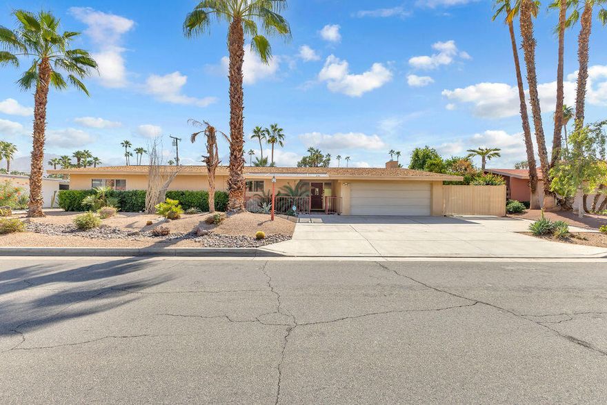 This classic mid-century ranch home blends timeless desert architecture with spacious modern living, perfectly situated near El Paseo's upscale shopping, dining, and entertainment. Featuring 4 bedrooms, 3 bathrooms, and approximately 2,757 sq. ft., the residence offers generous living areas and authentic character throughout.A formal living and dining room set the tone for elegant gatherings, while the expansive great room impresses with wood-beamed ceilings, abundant natural light, and a seamless connection to the open kitchen. The kitchen is well-appointed with a center island and a large picture window overlooking the sparkling pool -- ideal for entertaining or casual family living.Each bedroom is spacious, offering flexibility for guests, a home office, or a creative studio. The primary suite provides a comfortable retreat with a generous layout and ample natural light.Step outside to discover a resort-style backyard designed for relaxation and fun. A palm-framed pool with a charming bridge and island feature anchors the space, surrounded by lush landscaping and a wide covered patio perfect for dining or lounging in the shade.Practical amenities include owned solar panels, RV parking, a two-car garage, and a large driveway for extra guest parking. Combining mid-century charm, functional design, and a prime Palm Desert location, this home offers the ideal canvas for a stylish desert retreat or full-time residence.