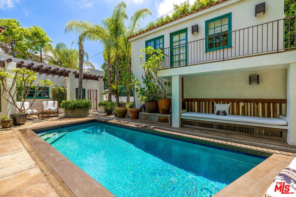 Tucked away in the heart of the iconic Sunset Strip, just moments from Chateau Marmont, this exceptional residence blends timeless Spanish architecture with tranquil Balinese influence. This 4-bedroom, 4-bathroom compound offers refined design, luxurious amenities, and rare privacy. The main house features three bedrooms, including a serene upstairs primary suite with dual walk-in closets and a spacious open-air terrace. Two guest bedrooms are located on the first floor, while a detached one-bedroom guest house overlooks the pool, ideal for visitors or a creative retreat. The chef's kitchen is equipped with professional-grade appliances and a climate-controlled wine cellar, opening to a sunlit dining room with fireplace and a cozy lounge. The expansive living room flows into a den/media room, with all main-level spaces connecting to lushly landscaped grounds. Outside, enjoy a resort-style salt-water pool, built-in BBQ kitchen, fire pit lounge area, and multiple entertaining areas surrounded by tropical landscaping. With gated parking for up to seven vehicles, this private estate captures the essence of elevated Los Angeles living.