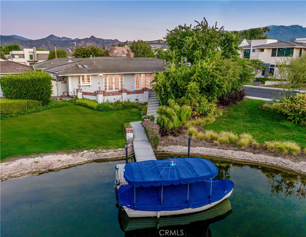 This luxurious single story is situated within the prestigious Gated community of Westlake Island, an oasis of beauty and sophistication nestled in the heart of Westlake Village. Stepping into the home you are greeted with an abundance of natural light that floods every corner. This home offers comfortable living spaces that seamlessly integrate with the amazing outdoor entertaining areas creating the ultimate California indoor/outdoor lifestyle home. The kitchen provides high end stainless steel appliances with custom cabinetry opening to the dining area. The primary bedroom is equally impressive, with picturesque windows that showcase stunning lake views. The spa like master bath boasts an abundance of closet and storage space. The secondary bedroom is oversized with plenty of closet space. Walk out to your dock just steps from your patio and enjoy a sunset cruise or dinner at the landing or Boccaccio's on the water. 24 hour guard gated community on the island & conveniently located to all.