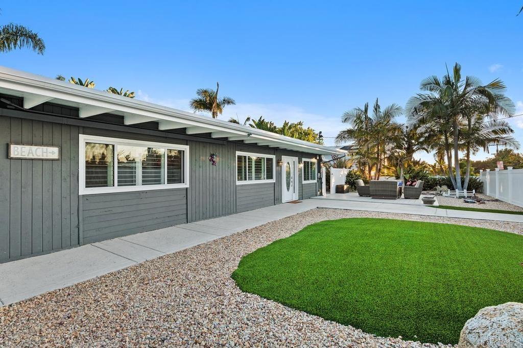 A rare opportunity in one of Encinitas' most special neighborhoods around! This turn-key gem is ready for you to spread out, soak up the summer sun, and unwind in your lush, tropical (yet low-maintenance!) yard. A spacious wraparound deck connects seamlessly to the home, blurring the lines between indoor comfort and outdoor living. Inside, the Primary Suite features cherry wood floors, a walk-in closet with convenient laundry access, and sliding sun shades. Entertain with ease in the built-in outdoor kitchen, store your surfboards in the dedicated storage room, or get creative in the fully finished garage, complete with insulation and a new floor. Newer owned solar (2022) adds energy efficiency, while the third bedroom—currently set up as an office with full closet and zoned heating and cooling—can easily be converted back to a bedroom. Full privacy fencing at the street gives the entire property a tucked-away feel—like your own private retreat. And with the permanent street barricade in place, it is your own cul-de-sac. Peace, quiet, and total privacy await!