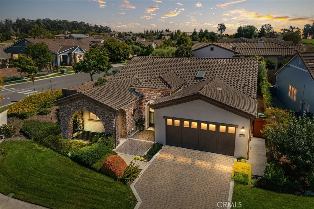 Resort living awaits in this Lopez home with a lovely stone facade, spacious porch and beautiful landscaping, located on the corner of a pristine cul-de-sac. At 2,079 sq. ft., this well-appointed home offers 2 bedrooms, 2 baths, and a den, plus a clever closet/partial garage conversion which has resulted in a spacious office/study, complete with gorgeous built-ins. Another notable upgrade - multiple skylight tubes throughout to bring in even more natural light. The great room features a cozy fireplace and luxury entertainment center which opens to the chef’s kitchen, a sunny breakfast nook, a built-in desk and direct patio access - it’s a great spot to enjoy your morning coffee while catching up on email. The adjacent chef’s kitchen offers a super efficient set-up featuring GE Profile stainless appliances, including a wall oven/microwave combo and gas cooktop, KitchenAid dishwasher, LG French door refrigerator, rich Shaker-style espresso cabinetry with lots of pot drawers, gorgeous granite island and countertops and smart pendant lighting. An extended Butler’s pantry is located in the adjacent formal dining room, making entertaining your guests a breeze. Head outside and experience a delightfully private and low-maintenance backyard with extensive pavers, planted with trees, shrubs and flowers - it’s your go-to spot to simply relax and enjoy Central Coast living. In the evenings, retire to your primary suite - a spacious bedroom with direct patio access, plus a master bath with dual sinks, decorative tile backsplash, tile shower with seamless glass enclosure, a large walk-in closet and linen storage. Up front is the 2nd bedroom with a full en-suite bath, plus the den, which could easily be converted into a 3rd bedroom. In addition, there’s a laundry and 2-car garage. Best of all, this delightful Lopez home is located in Trilogy Monarch Dunes with Adelina’s Bistro, Sandalwood Spa, art studio, pool, fitness center, pickleball courts, and so much more.