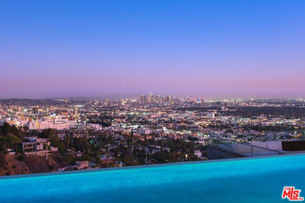 A breathtaking architectural tour-de-force in Mount Olympus, offering head-on, unobstructed views from downtown to the ocean. This rare, expansive lot features a massive motor court behind security gates, as well as a large, flat rear yard with an infinity-edge pool, spa, fire pit area, patios, decks, and a sprawling lawn. The approximately 6,200 sqft home includes 4 bedrooms and 5 bathrooms, with vast entertaining rooms, including a living room, dining room, two-story glass-walled conservatory, and a kitchen/family/great room all overlooking the sweeping views. The luxurious primary suite also opens directly to the vistas and features its own private deck, a sitting room, a spa-like bath, and a custom-built walk-in closet. The chef's kitchen boasts high-end stainless steel appliances and an oversized eat-in island. All of this is just above the Sunset Strip and within close proximity to the restaurants, shops, and attractions of West Hollywood, Beverly Hills, and Hollywood proper.