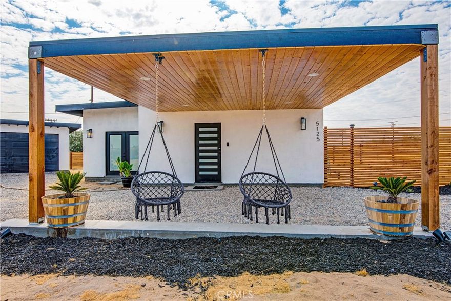 BACK ON THE MARKET! Discover modern desert living in this brand-new 2024 construction, nestled in the heart of Joshua Tree.

This 1,205 sq. ft. contemporary retreat blends smart home technology, full-electric efficiency, and a fully paid 7kW solar system with the timeless beauty of the desert landscape. Featuring 2 spacious bedrooms, 2 bathrooms, and an airy open-concept layout, the home sits on a generous 13,500 sq. ft. lot, offering ample room for both relaxation and entertainment. As you arrive, a custom carport with two inviting swings sets the tone for the playful yet peaceful atmosphere. Inside, the designer kitchen and living area flow seamlessly to accordion glass doors that expand the space onto your private backyard haven. Here, you’ll find a BBQ area with a grill ready to cook, a cozy fire pit, a volleyball court, and space for mini golf and cornhole.

For even more fun, the garage has been transformed into a game room, complete with pickleball, arcade basketball, classic arcade games, and plenty of bean bags for board games—all while enjoying stargazing under Joshua Tree’s expansive night skies. Already operating as an active Airbnb, this property offers immediate income potential while also serving as the perfect personal desert retreat. Its prime location places you just minutes from Joshua Tree National Park, local restaurants, and the captivating “Transmission” art installation. Every detail of this property has been thoughtfully curated to provide both modern luxury and soulful tranquility. Whether you’re looking for a personal escape or a high-performing investment property, this one-of-a-kind residence is ready to inspire.