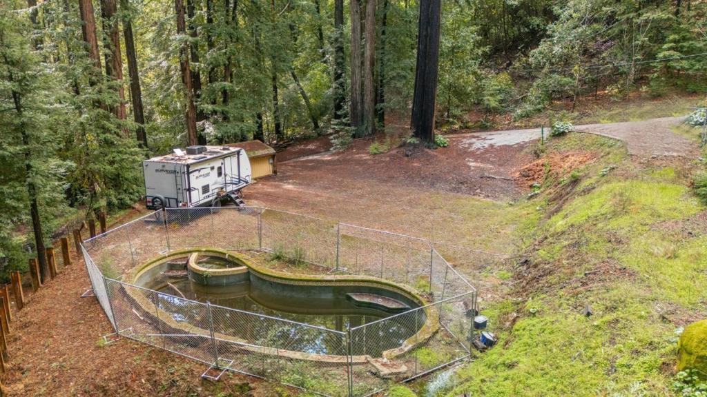 Ready to build your dream home in a sunny redwood paradise? This dome-shaped home with pool was unfortunately destroyed in the 2020 CZU fire, but a significant portion of the groundwork for building has already been completed by both the current and previous seller. There is a PG&E power pole located in front of the driveway with a temporary meter. The undamaged septic system has been inspected and cleared by the Environmental Health Department. The well was previously repaired by the last seller and exclusively services this property. The structure site has received phase 1 & 2 clearance for debris removal, as well as Geo and Fire Protection clearances. Pre-clearance has been obtained for a 2636 sqft, 2-bedroom, 2-bathroom house with an attached garage and storage unit. An approved temporary housing permit for a construction trailer has been granted in the past. If the 2.8 acres aren't sufficient, this property is nestled between Big Basin and Castle Rock state parks. It offers an easy commute to Saratoga, Silicon Valley, and Boulder Creek. Searching for the perfect buyer to restore this property to all its glory. Truly a must-see!