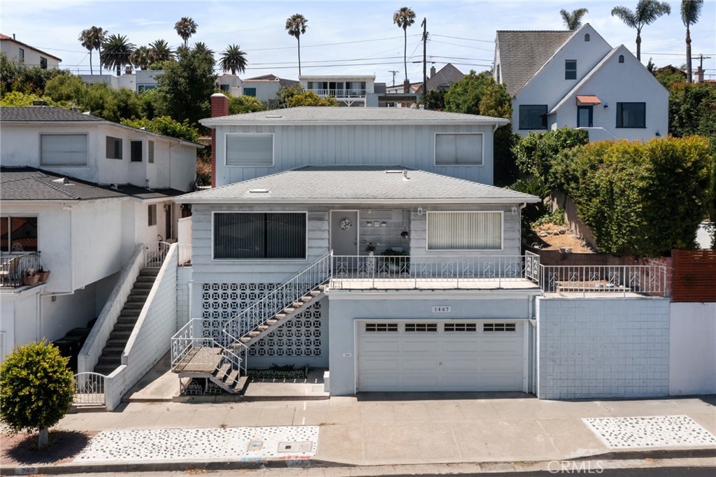 Breathtaking, unobstructed views of the harbor and LA mountains set the tone for this special home located in the desirable Vista Del Oro community in San Pedro. Above the garage, at the main level, a welcoming patio offers a lovely place to take in the scenery. Also at the main level is located the upgraded kitchen featuring charming dual toned T&G paneled cabinetry, a tiled backsplash, a farmhouse sink, a large pantry, laundry area, and views from the dining room right off the kitchen, allowing for a bright and airy space. A new water heater adds convenience. The living room is bright and open with panoramic windows, a wood-burning fireplace, and a newer sliding door that opens to the backyard. The first level also enjoys the convenience of a powder room.
Upstairs, the views continue from the primary bedroom, which includes its own bathroom with an upgraded shower. A full bath in the hallway serves two additional bedrooms—one of which also enjoys the view. The upstairs rooms also have fans and carpet.
The home is situated at the front of the oversize lot, leaving a rare, flat 3,500 sq. ft. upper section at the back of the property. With even more expansive views, this space offers potential to build an ADU (buyer to verify with the city) and could enjoy unobstructed vistas. An ideal opportunity for multigenerational living or a savvy investor.