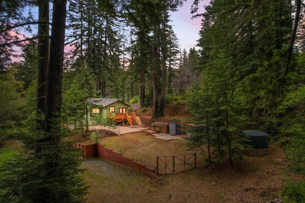 Santa Cruz Mountains. With wonderful curb appeal and set on nearly half an acre, this property looks like it belongs on HGTV. Enjoy summer evenings on the spacious back deck, where you can relax with an apéritif while listening to the birds and watching breathtaking sunsets. The kitchen serves as the heart of the home, featuring gorgeous green cabinets, modern light fixtures, and stainless steel appliances that add a touch of elegance and functionality. The mostly flat yard is perfect for gardening, lawn games, or simply unwinding by the pond with your morning coffee. Excellent separation of space between the two bedrooms ensures privacy and comfort. Conveniently located near downtown Ben Lomond, youll be just moments away from local favorites like Aroma, as well as scenic hiking and mountain biking trails. The beaches of Santa Cruz are within easy reach, and quick access via Bear Creek Road or Highway 9 makes commuting to Silicon Valley a breeze.