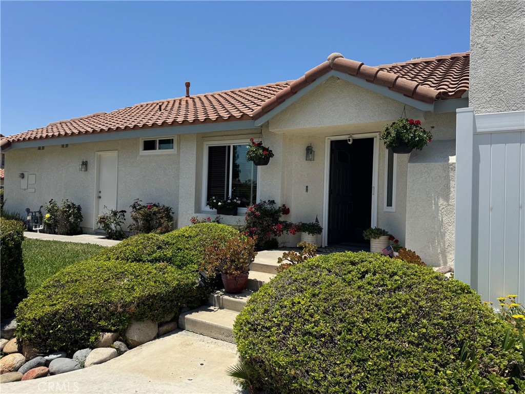 Charming SINGLE-LEVEL House on a CORNER LOT – 2 Bed, 2 Bath, 2-Car Garage! Don’t miss this rare opportunity! This beautiful single-family residence sits on a spacious corner lot and features 2 bedrooms, 2 bathrooms, and an attached 2-car garage. With a wraparound yard, low HOA under $100/month, and NO Mello-Roos, this house offers both comfort and value in a desirable neighborhood. Step inside to a welcoming living room with a cozy fireplace, seamlessly connected to the dining area. A decorative chandelier adds charm and elegance, while the updated windows and blinds bring in abundant natural light. The remodeled kitchen is a true highlight – featuring upgraded cabinetry with soft-close doors and drawers, new countertops, and modern appliances. Designed for entertaining, the kitchen, dining, and living spaces all flow out to the private wraparound yard through a sliding glass door, creating an ideal indoor-outdoor lifestyle. Enjoy wall-to-wall windows offering views of the landscaped yard, enclosed with new vinyl fencing for added privacy. Down the hall, you’ll find ample storage with linen and coat closets, a spacious primary suite with en-suite bathroom, and a comfortable secondary bedroom with easy access to the second full bath. At the end of the hall is direct access to an oversized 2-car garage – perfect for extra storage or a workshop space.This home combines charm, function, and thoughtful upgrades throughout. Properties like this do not come up often! In close proximity to parks, tennis, shopping, dining and much more. Don't miss the opportunity to see this gem.