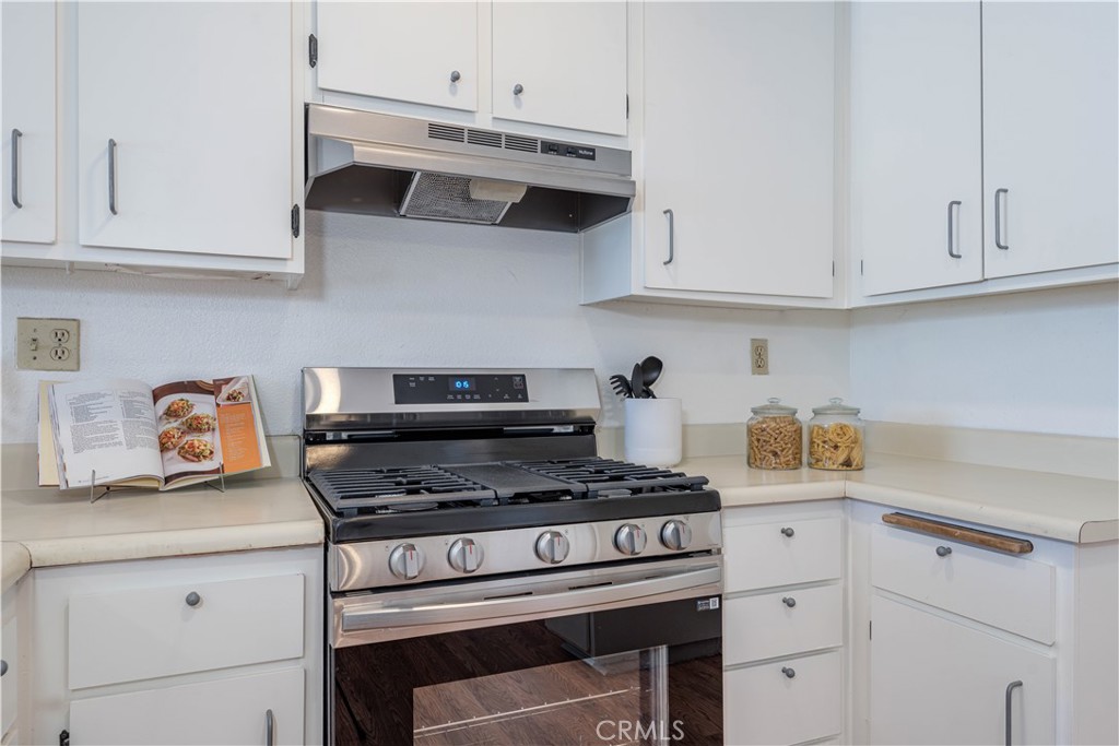 This stunning 2-bedroom, 2-bathroom condo features 830 sq. ft. of thoughtfully designed living space, complete with two inviting balconies that serve as perfect retreats for relaxation. The property includes a detached 2-car garage #40 & #41 conveniently located just a short stroll away, ensuring ease and security for your vehicles. The unit offers a private atmosphere, enhanced by a separate entrance that welcomes you into your own tranquil sanctuary. Inside, you will find a newly painted interior. The kitchen boasts ample counter and cupboard space, a new stainless-steel free-standing range, a serve-over bar for casual dining, and an adjacent eat-in dining area. The primary bedroom is truly an oasis, boasting a beautifully upgraded en suite bathroom with quartz countertops, a new modern vanity with new fixtures, new mirror lighting and dual sinks. This bedroom also opens to a large balcony, providing additional options for relaxation. The secondary bedroom offers extra living space and a full, upgraded bathroom includes a new vanity and fixtures and new modern mirror lighting. Practical features include washer and dryer hookups, making laundry days a breeze. On warm days, residents can enjoy exclusive access to a sparkling community pool, perfect for cooling off or unwinding under the sun. Nestled behind a security gate, this home offers an oasis of privacy while being part of a beautifully maintained community. The homeowner's association (HOA) provides a low monthly fee that includes water and trash services, adding to the ease of living here. Its prime location near the 22 freeway ensures quick access to nearby destinations, while the Garden Grove Shopping Center—just a leisurely walk away—features a delightful array of dining options and grocery stores, making it ideal for both work and play. With ample guest parking available and a warm, welcoming neighborhood community, this residence promises incredible value.