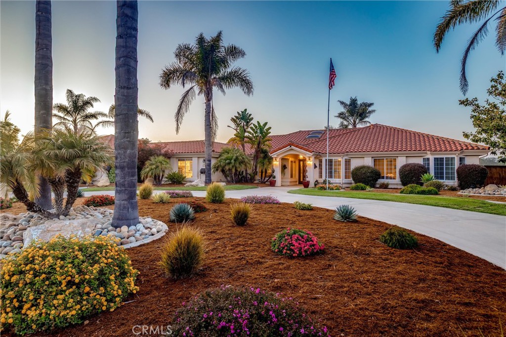 Welcome to your new home, your own private resort on Camino Roble. A rare, single-level sanctuary where every detail has been curated to elevate your lifestyle. Set on a full acre in one of Nipomo’s most coveted neighborhoods, this custom-built Greg Nester home blends refined luxury with the natural beauty of the Central
Coast. From the moment you arrive, the grand circular driveway, lush palm-framed landscaping, and sweeping 180° mountain views create a breathtaking first impression. Inside, Acacia hardwood floors flow beneath vaulted ceilings, while whole-home sound, security, and a spa-inspired primary suite with Turkish limestone, Hansgrohe fixtures, and jacuzzi tub offer everyday indulgence. Designed for effortless indoor-outdoor living, this home is anchored by expansive patios, vibrant hydrangeas, and a backyard retreat that rivals any resort—complete with a putting green, bocce court, and 18+ yards of sculpted concrete walkways.
But what truly sets this estate apart is its potential. Included plans for a 750 SF ADU and up to a 1000 sq ft. garage with mezzanine and RV pad open the door to multigenerational living, income opportunity, or your dream car workshop. The ¼-acre lower terrace is a blank canvas—ideal for a vineyard, orchard, or garden sanctuary. Just one block from parks and walking trails, and minutes from world-class golf, drive-on beaches, surf breaks, and over 300 local wineries, this is where tranquility, opportunity, and everyday luxury meet. Imagine living not just in a home—but in a destination.