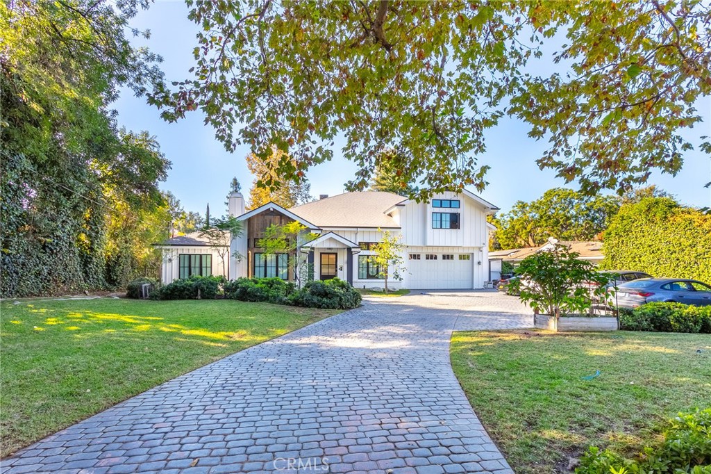 Welcome to a breathtaking luxury compound, situated south of the Boulevard on a flat, half-acre lot along one of Tarzana's finest streets. This private retreat greets you with a long, gated driveway, leading through a serene, park-like front yard and setting the stage for an extraordinary living experience. The grand entrance features a stunning 20-foot ceiling foyer that flows seamlessly into the expansive Great Room, perfect for entertaining or relaxing. Adjacent is a magazine-worthy Chef's kitchen, boasting top-of-the-line appliances, exquisite finishes, and an inviting layout for culinary creations and social gatherings. Designed with entertainment in mind, the home's bi-fold doors open to an exceptional backyard oasis. This entertainer's paradise includes a sprawling patio, a sparkling pool, a rejuvenating spa, a fully equipped summer kitchen, and a cozy fire pit. Additionally, enjoy the convenience of an outdoor shower for those sun-soaked afternoons by the pool. Every detail of this estate speaks to luxury and comfort. The property features dual primary suites, one conveniently located on the main floor, with additional oversized bedrooms that rival traditional primary suites in scale and elegance. Other highlights include a formal dining room for large gatherings, a formal living room, a state-of-the-art movie theater and an ADU/pool house for guests or flexible use. Smart technology enhances the home with a Savant system, CCTV cameras and alarm system for added security, and advanced features like a steam shower to elevate your living experience. Car enthusiasts will appreciate the ample parking space, perfect for showcasing a collection. This unique home is the epitome of upscale living, offering a rare blend of grandeur, comfort, and modern sophistication. Experience the pinnacle of luxury in this one-of-a-kind Tarzana estate.